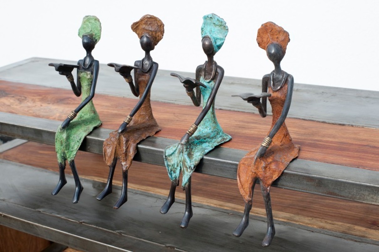 Alt.-Text: Vier sitzende Bronzefiguren, die je ein Buch in der Hand halten. 