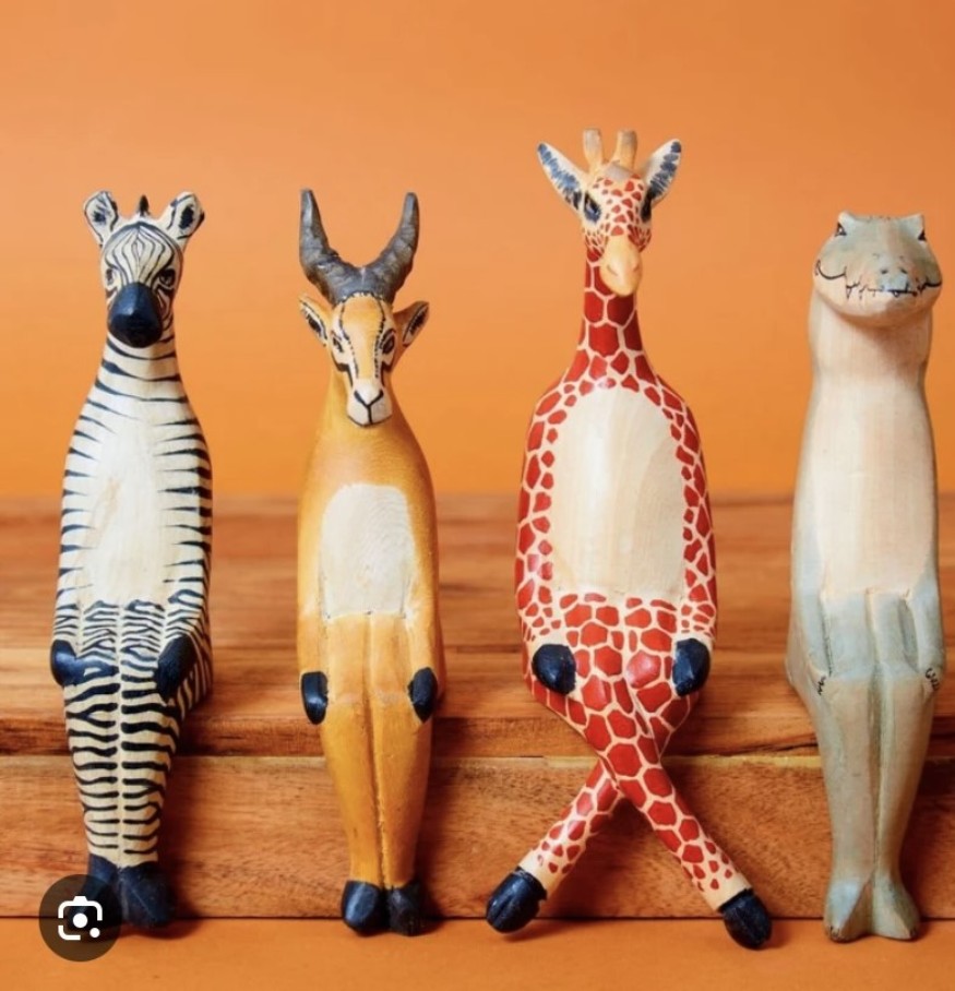 Wooden animal figures, an antelope, a giraffe and a crocodile.