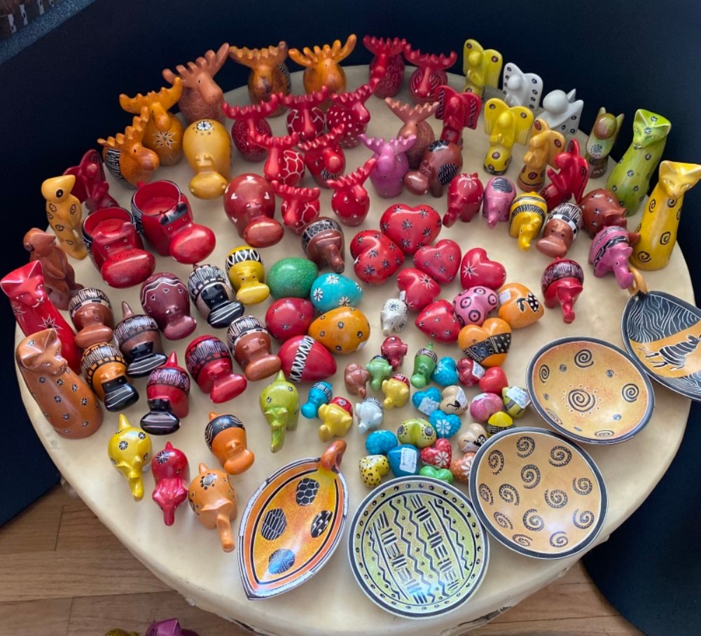 Colourful figures and bowls with patterns lie on a table.