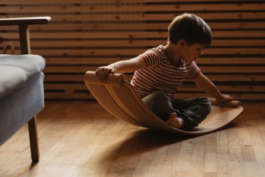 A toddler on a curved wooden board