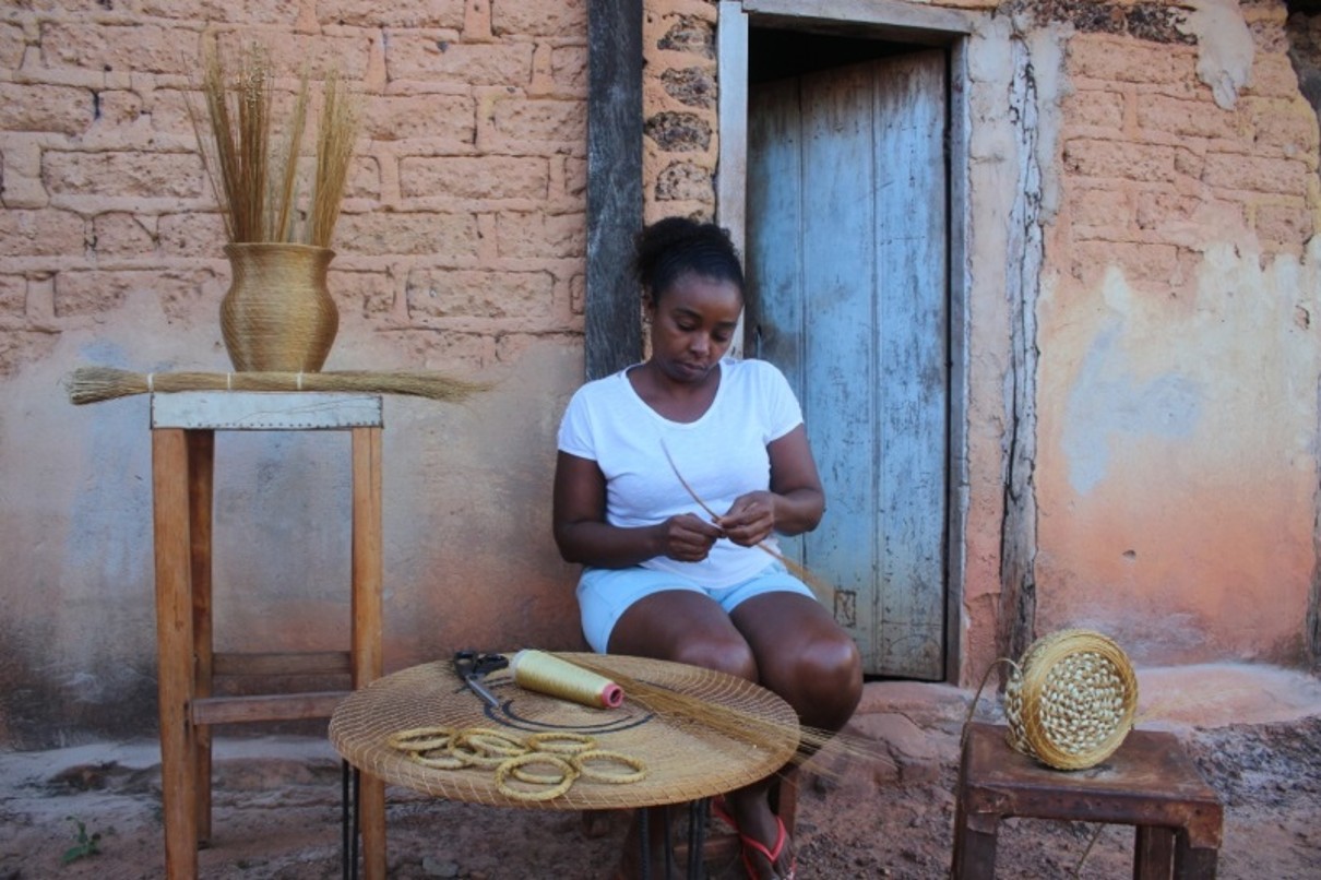 A woman tying blades of grass.