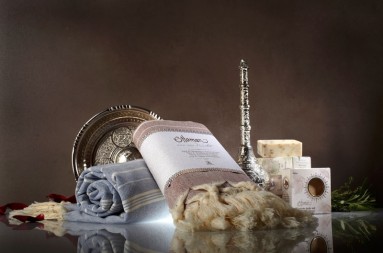 Soaps, two towels and silverware against a brown background.