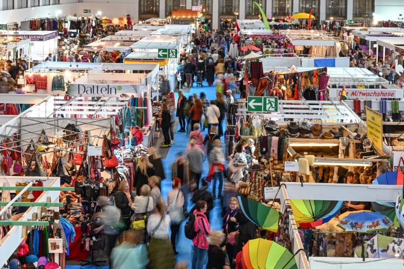 Groups of people surrounded by colourfully decorated exhibition stands